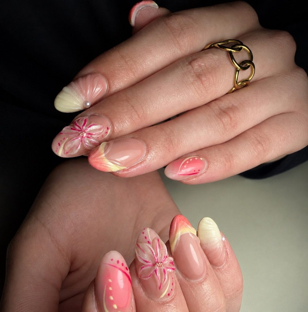 Amandelnagels in zacht roze en perzik met een bloemetje